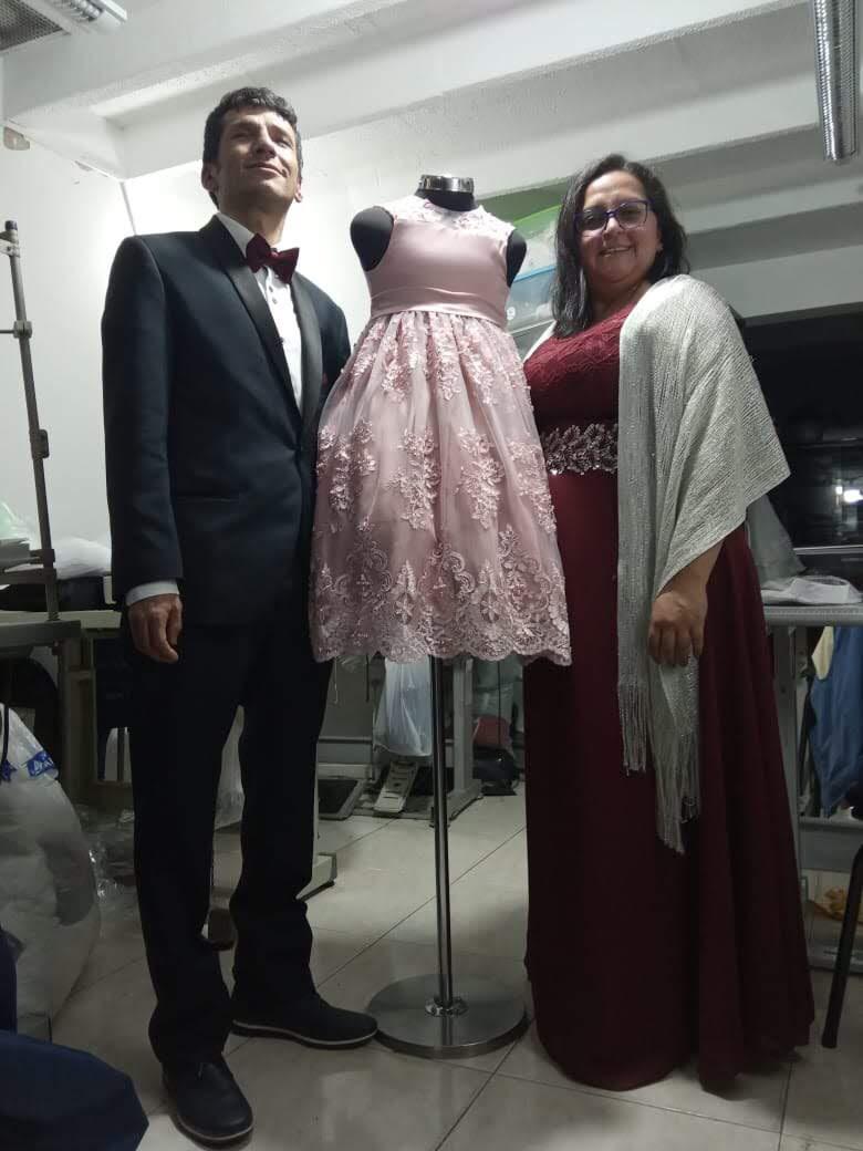 foto de alexander y su esposa presentando un vestido de primera comunión
